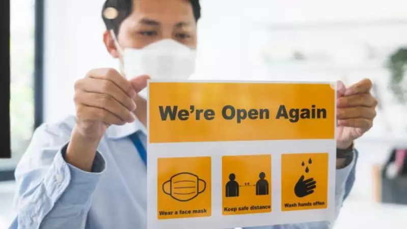 Businessman with open again sign